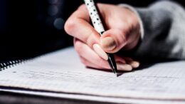 A female student writes notes in class